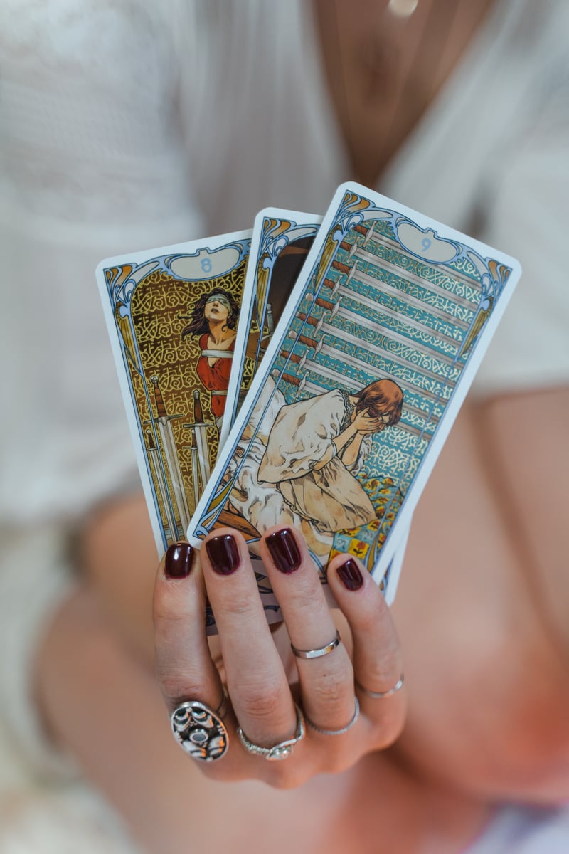 Person Holding Three Tarot Cards 